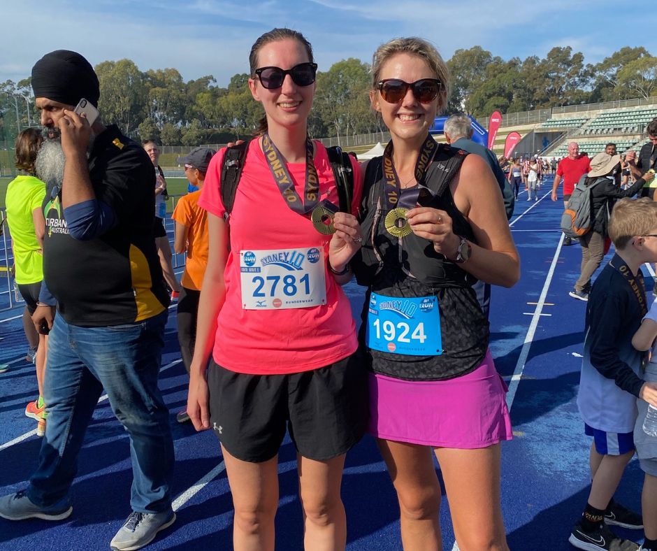 Smiling runners holders medals at Sydney 10k event
