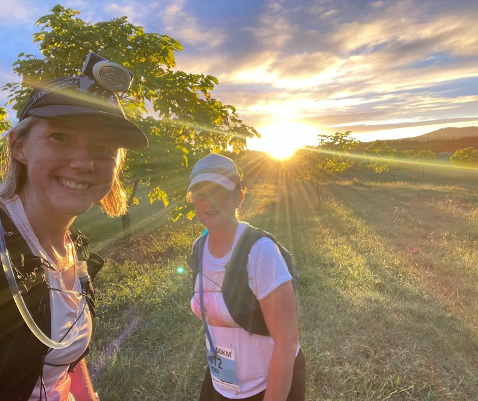 Smiling ultra marathoners in the bush at sunset