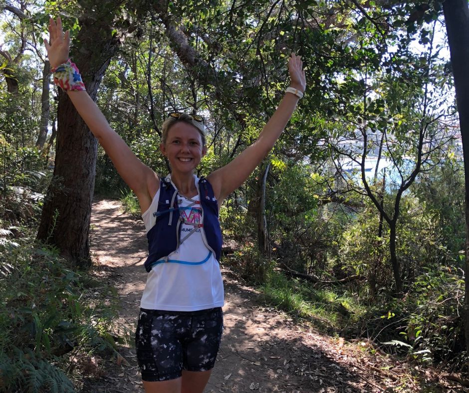 Smiling Trail Runner with arms in the air