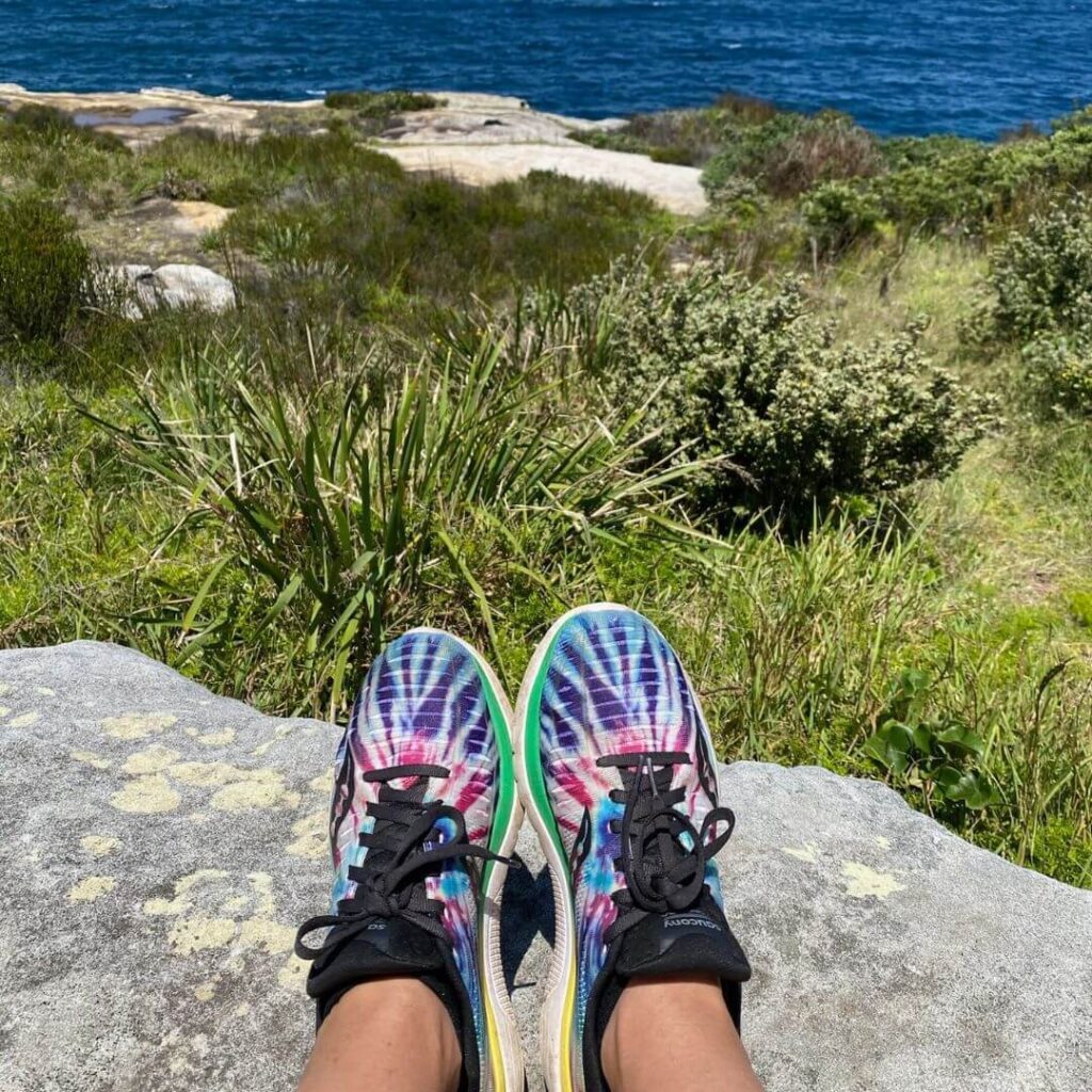 Colourful running shoes with bush and sea in the background