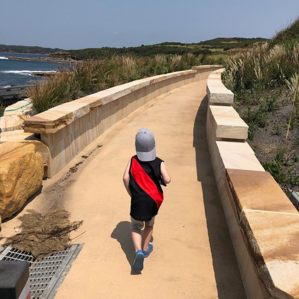 Child running on coastal path