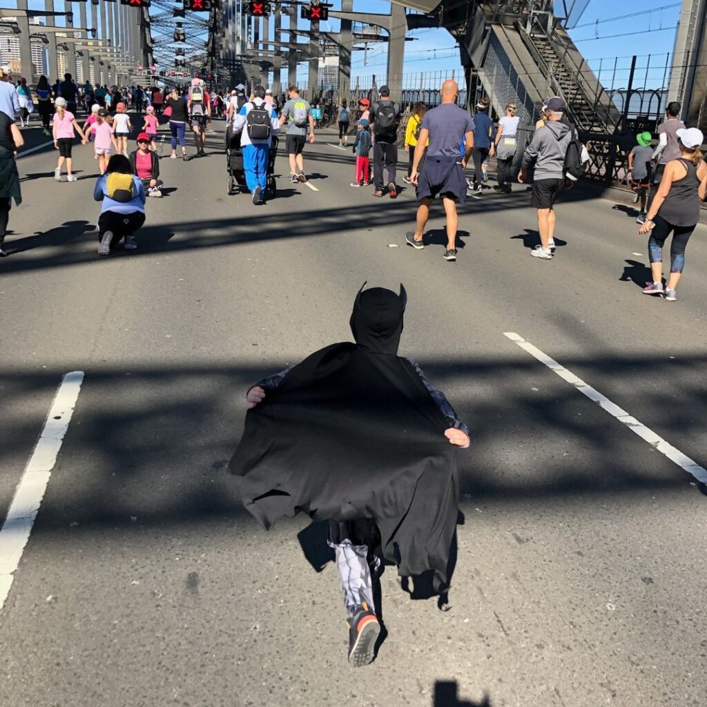 Child running at Fun Run in Batman outfit