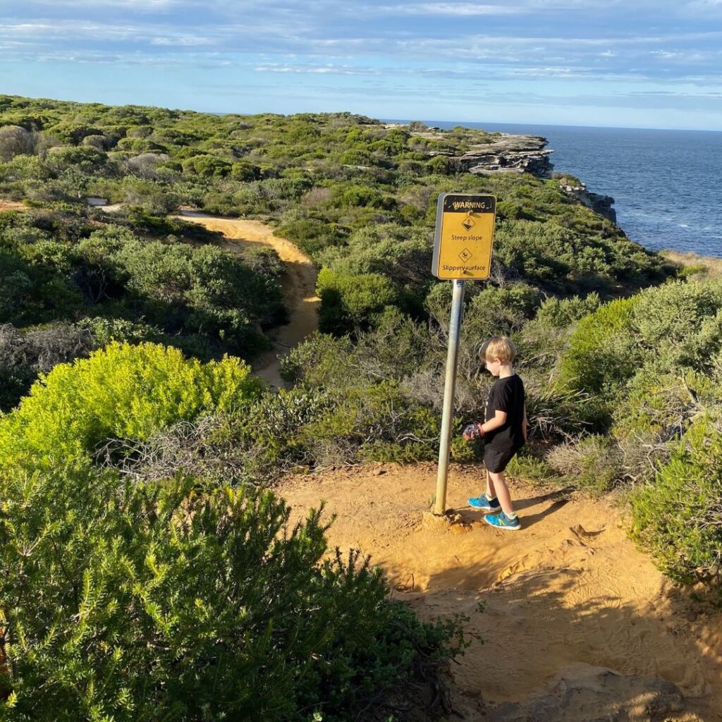 Child near sign on National Park trail