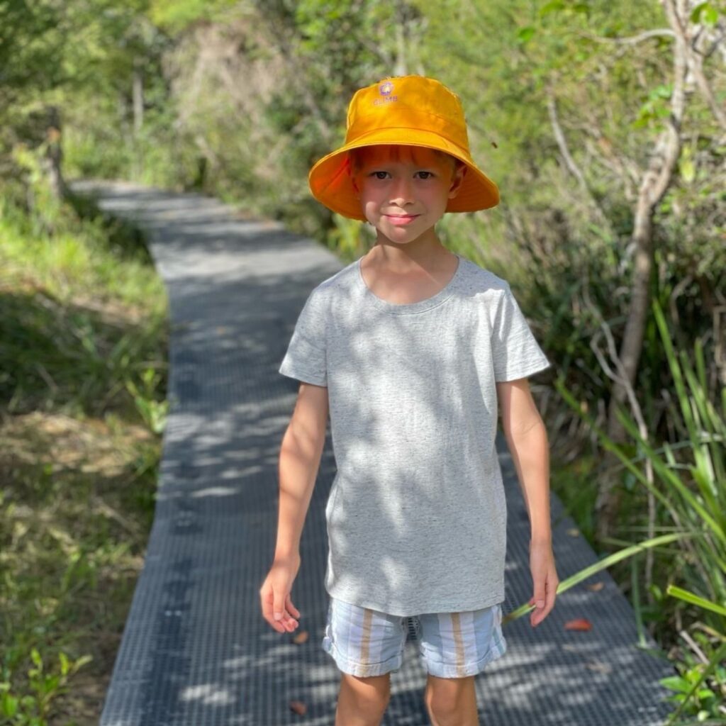 Child with yellow hat on foot path